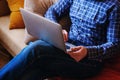 Young man working with computer on the beach. Handsome man working with laptop laying on the couch at the beach Royalty Free Stock Photo