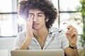 Young man working with computer while rubbing his eye Royalty Free Stock Photo