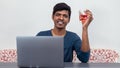 A young man is working on his laptop while holding a glass of red wine Royalty Free Stock Photo