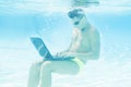 Young man working with his laptop underwater Royalty Free Stock Photo