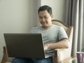 Young Man Working at Home on His Laptop, Smiling Expression