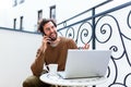 Young man working from home using smart phone and notebook computer.Portrait of businessman talking on mobile phone and drinking Royalty Free Stock Photo