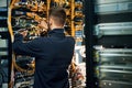 Young man is working with internet equipment and wires in server room Royalty Free Stock Photo