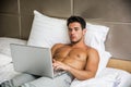 Young Man Working on Laptop in Bedroom Royalty Free Stock Photo