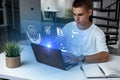 Young man working on laptop with holographic screen in modern workspace setting Royalty Free Stock Photo