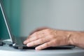 Young man working with laptop, man`s hands on notebook computer, business person at workplace Royalty Free Stock Photo