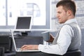 Young man working in office using laptop Royalty Free Stock Photo