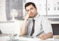 Young man working in office writing notes thinking Royalty Free Stock Photo