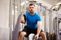 Young man working out with battle ropes at a gym