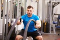 Young man working out with battle ropes at a gym Royalty Free Stock Photo