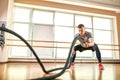 Young man working out with battle ropes at a gym Royalty Free Stock Photo