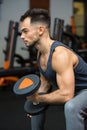 young man working out biceps in front mirro