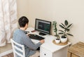 Young man working at a table with a computer on his working place. working at home. freelancer Royalty Free Stock Photo