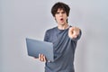 Young man working using computer laptop pointing with finger to the camera and to you, confident gesture looking serious Royalty Free Stock Photo