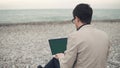 Young man works on the beach.