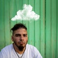 Young man with a worried and despondent face with a cloud over his head