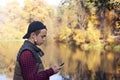 Young man writes a message in an autumn park Royalty Free Stock Photo