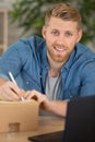 young man writing address to send package Royalty Free Stock Photo