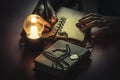 Young man writing on a blank page of a vintage leather book under the low light condition with a yellow, light bulb Royalty Free Stock Photo