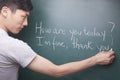 Young man writing English sentences on the blackboard Royalty Free Stock Photo