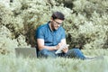 Young man writing in his sketchbook in city park Royalty Free Stock Photo