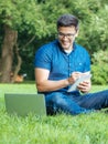 Young man writing in his sketchbook in city park Royalty Free Stock Photo