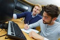 young man writing on note in front computer screen Royalty Free Stock Photo