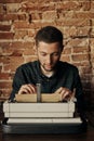 Young man writing on old typewriter. Royalty Free Stock Photo