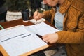 Young man writing in sketchbook in street Royalty Free Stock Photo