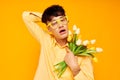 A young man in yellow glasses with a bouquet of flowers holiday unaltered Royalty Free Stock Photo