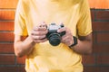 young man holds in his hands an analogical camera