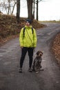 young man in a yellow jacket aged 20-24 on a walk with a Czech mustache a hunting dog. Binary portrait of taking care of pet
