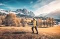 Young man in yellow jacket with backpack is walking on the meado Royalty Free Stock Photo