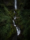 Young man in yellow jacket in front of El Chorro de Giron waterfall cascade cataract near Cuenca Azuay Ecuador