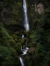 Young man in yellow jacket in front of El Chorro de Giron waterfall cascade cataract near Cuenca Azuay Ecuador