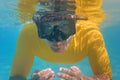 Young man in yellow shirt swimming under water face covered with diving or snorkelling mask, closeup front detail Royalty Free Stock Photo