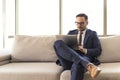 Young manager sitting on sofa reading mails Royalty Free Stock Photo