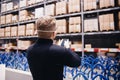 Young manager of store, man worker with protective mask using phone working in industrial factory or warehouse Royalty Free Stock Photo