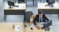 A young manager in a suit and a secretary entered the office on a holiday to clean up the pending work