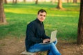 The young manager working on a laptop in the park. Lunch Break Royalty Free Stock Photo