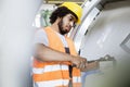 Young manual worker tightening bolts on machinery in factory