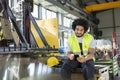 Young manual worker using mobile phone in metal industry Royalty Free Stock Photo