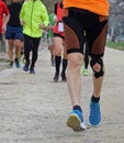 Young marathoner runs with athletic taping on the his knee durin Royalty Free Stock Photo