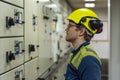 Young marine engineer in front of control panel during his daily routine work in engine room. Seafarers life. Royalty Free Stock Photo