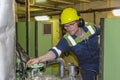 Young marine engineer during his round, checking operational parameters of engine room machineries on a merchant ship. Royalty Free Stock Photo