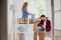 Young marriage packing stuff into boxes during relocation to new home Royalty Free Stock Photo