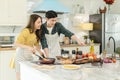 Young married couple Cooking breakfast By looking at how to make a laptop computer with a happy expression In their own home Royalty Free Stock Photo