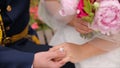 Young married couple holding hands, ceremony wedding day. Close up Groom Put the Wedding Ring on bride Royalty Free Stock Photo