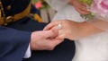 Young married couple holding hands, ceremony wedding day. Close up Groom Put the Wedding Ring on bride Royalty Free Stock Photo