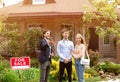 Young married couple meeting real estate manager to look at house for sale, outside Royalty Free Stock Photo